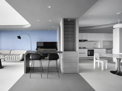 A modern living room with a concrete floor, black and white color scheme, and a piano.