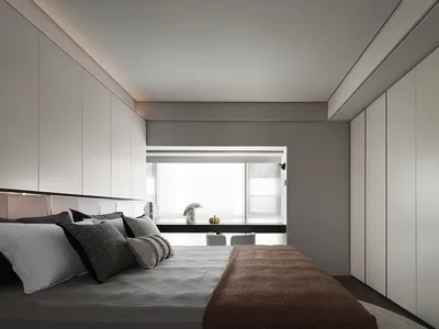 A modern minimalist bedroom with a bed, windows, and white cabinets.