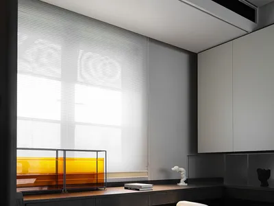 A minimalist bedroom with wooden furniture, glass panels, and metal accents.