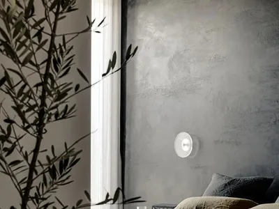 A minimalist bedroom featuring a concrete wall and bed with olive green bedding.