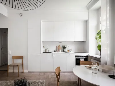 A modern minimalist kitchen featuring white cabinetry and a sleek, contemporary design.