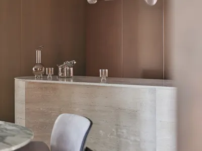 Modern bar counter featuring glass, brass, and marble materials.
