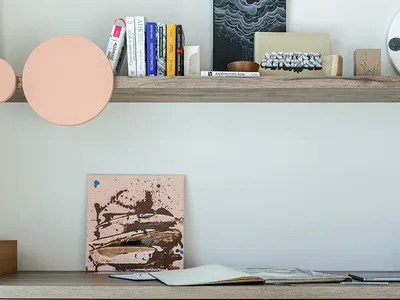 Modern home office setup featuring a wooden desk with a terrazzo drawer, a black sculptural chair, and various books on a flo