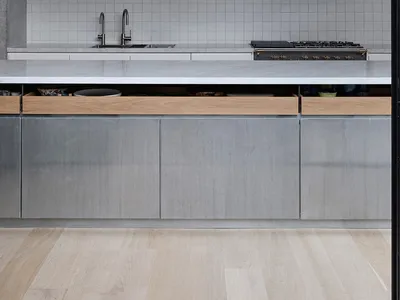 A modern minimalist kitchen with concrete and marble finishes.
