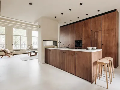 A modern kitchen featuring wooden cabinets and white flooring.