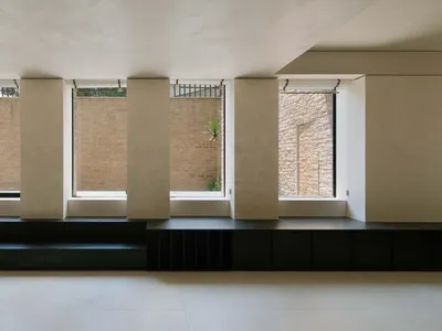 A minimalist interior design featuring concrete elements in a living room setting.