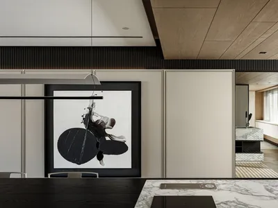 A modern dining area with marble countertops, featuring a large abstract painting on the wall.