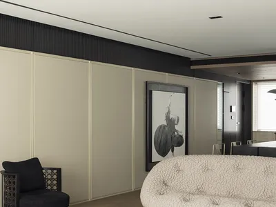 Modern minimalist living room with beige and black accents, featuring a comfortable sofa, armchair, and abstract wall art.