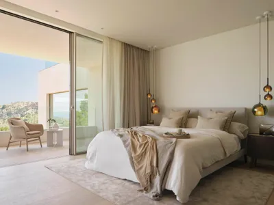 Minimalist bedroom featuring a glass wall, fabric bedding, and wooden floor.