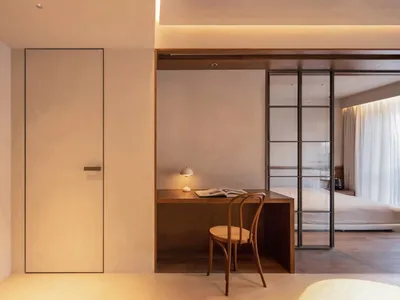 Modern minimalist bedroom featuring wooden furniture and soft lighting.