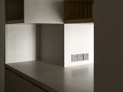 Modern minimalist kitchen with white concrete countertops and sleek, clean lines.
