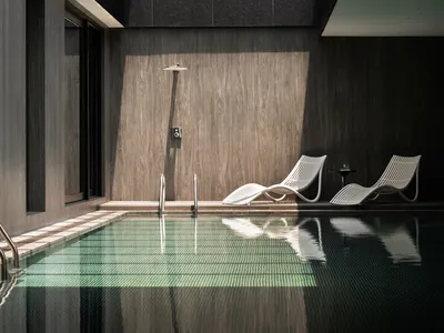 Indoor swimming pool with glass and concrete elements at a luxury resort hotel.