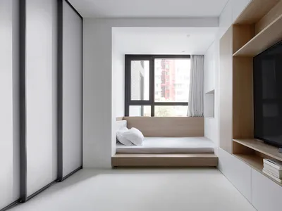 A minimalist bedroom with a bed platform, window, and built-in shelves.