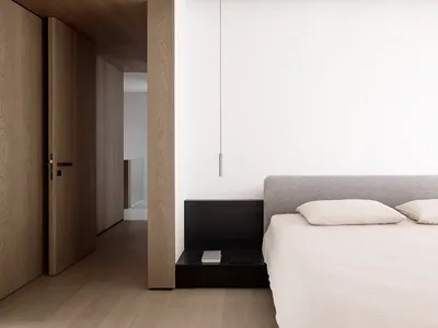 Minimalist bedroom featuring a textured wood floor and marble countertop