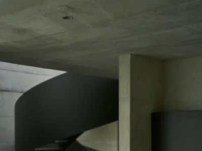 A modern minimalist kitchen with a spiral staircase in concrete.