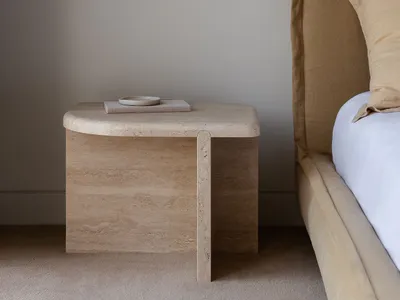 A modern bedside table with a brown bed frame and a hanging light fixture.