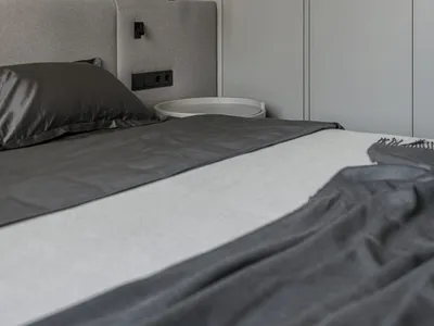A modern bedroom featuring gray upholstered furniture and fabric materials.