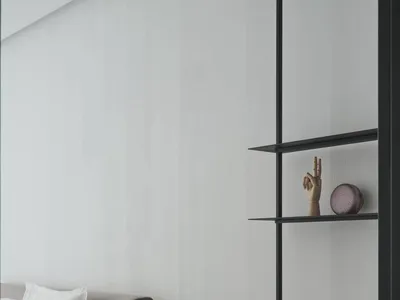 A minimalist bedroom with a white bed, floating desk, and open shelves.
