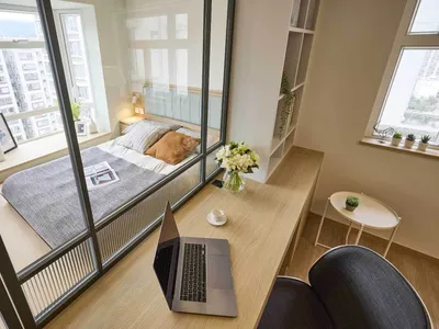 A minimalist bedroom featuring wood furniture, glass walls, and fabric bedding.