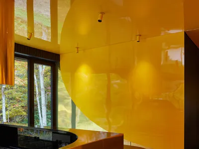 A modern kitchen featuring yellow glass surfaces and metal accents.