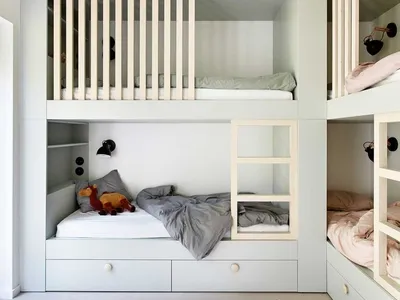 A minimalist children's bedroom with light wood bunk beds and white panels.