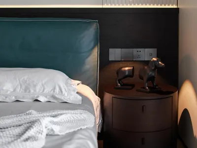 Modern minimalist bedroom featuring a wooden bed with a teal headboard and a metallic pendant light fixture.