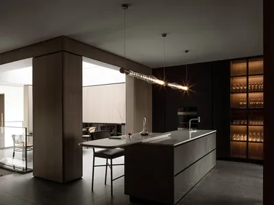Modern minimalist black kitchen with marble countertop and pendant lighting.