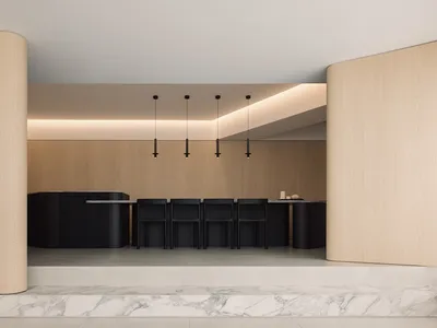 Modern kitchen with wooden countertop and chairs.