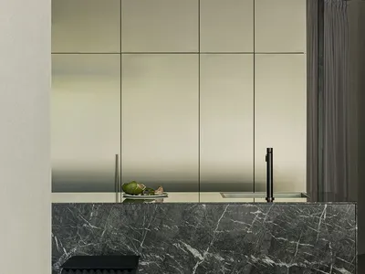 Modern kitchen featuring a sleek, minimalist design with dark marble countertops and stainless steel cabinets.