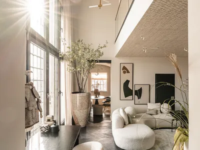 A modern, minimalist living room with contemporary furniture and glass walls.