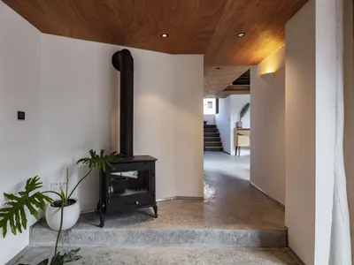 Modern industrial living room with concrete floor and wood elements.