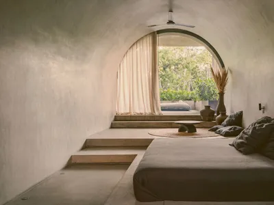 Modern concrete bedroom with a minimalist design and natural light.
