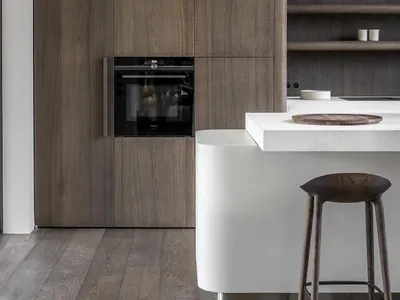 A modern kitchen with wooden cabinets and a white countertop.