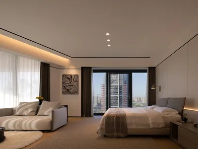 Minimalist bedroom with a view of the city, featuring a large bed, a comfortable sofa, and contemporary furnishings.