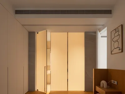 A modern minimalist bedroom with wooden flooring, marble accents, and a light-filled atmosphere.
