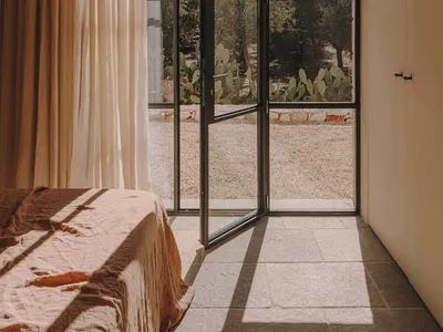 Modern bedroom with glass door and concrete floor