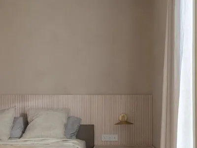 A minimalist bedroom featuring a floating nightstand, wooden headboard, and a window with curtains.