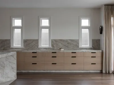 Modern minimalist kitchen with natural wood cabinets and marble countertop.