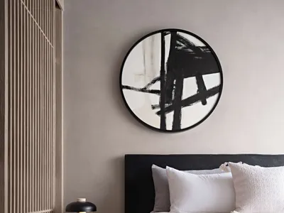 A minimalist bedroom with a black-framed bed, white bedding, neutral-toned wall paint, and a black side table lamp.