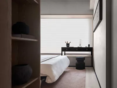 Minimalist bathroom with a white tub, sink, and mirror on a light-colored floor.