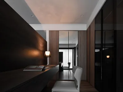 A minimalist home office featuring dark wood surfaces and a sleek, modern design.