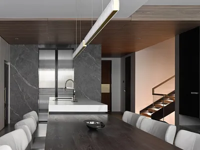 A modern kitchen and dining area featuring marble surfaces.