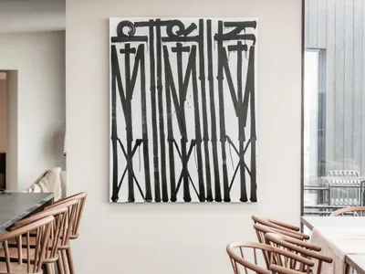 Modern restaurant interior with a bold black artwork on the wall and wooden furniture.