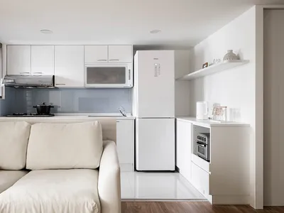 A minimalist kitchen with white cabinets and a modern design.