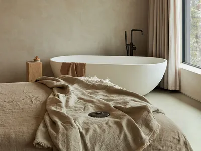 A minimalist bedroom featuring a cotton-blend blanket and curtains.