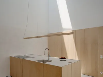 Modern kitchen with wooden cabinets and a skylight.