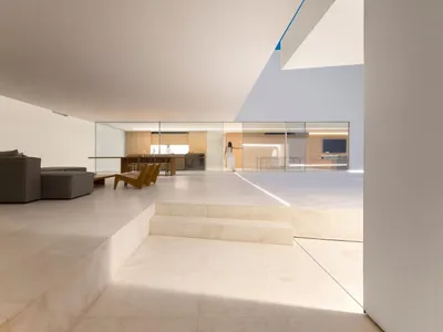 Living room with minimalist design featuring concrete and glass elements