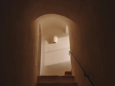 室內建築中一條狹窄的石階，配有金屬扶手。