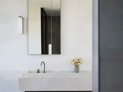 Modern minimalist bathroom featuring a marble countertop and a tall rectangular mirror.