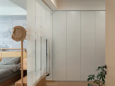 Modern minimalist bedroom with a glass door cabinet and a wooden bed frame and headboard.